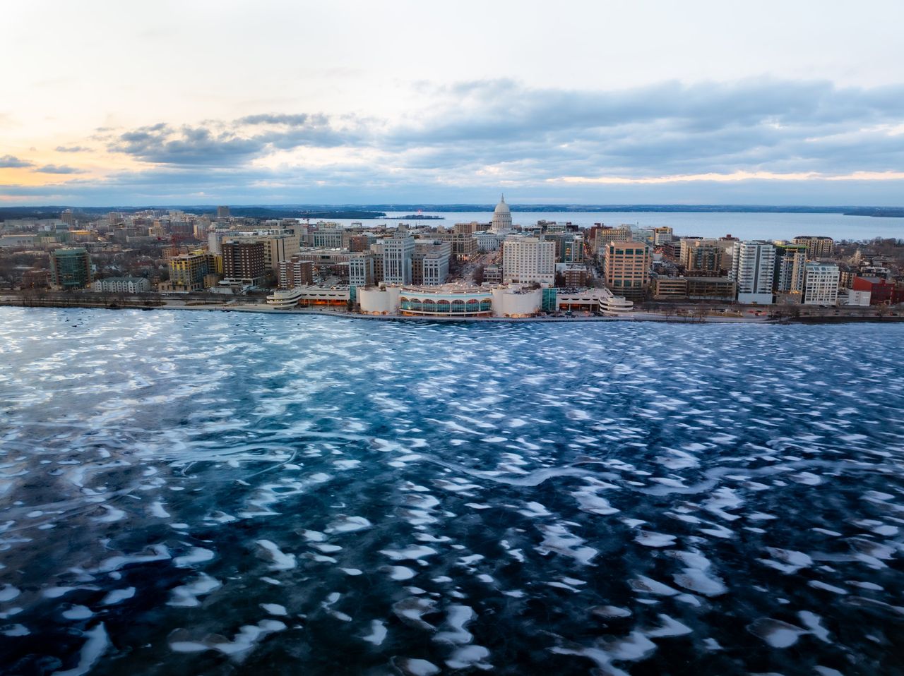 A snowy and frozen Lake Monona with the Monona Terrace and Madison Capitol in the background