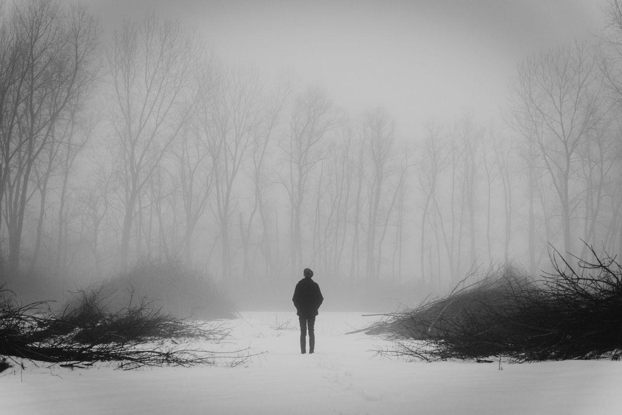 A person standing in foggy, snowy field
